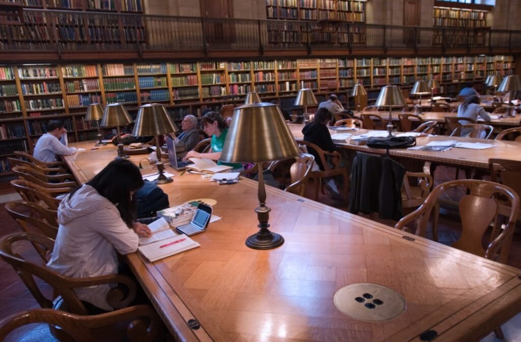 International students studying in Canada with books and laptops